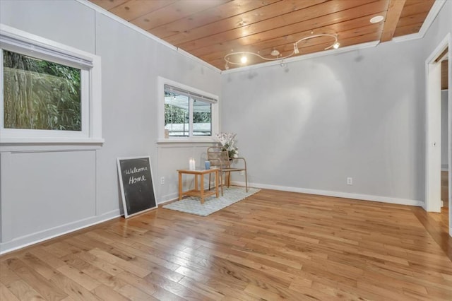 unfurnished room featuring ornamental molding, light hardwood / wood-style flooring, and wood ceiling