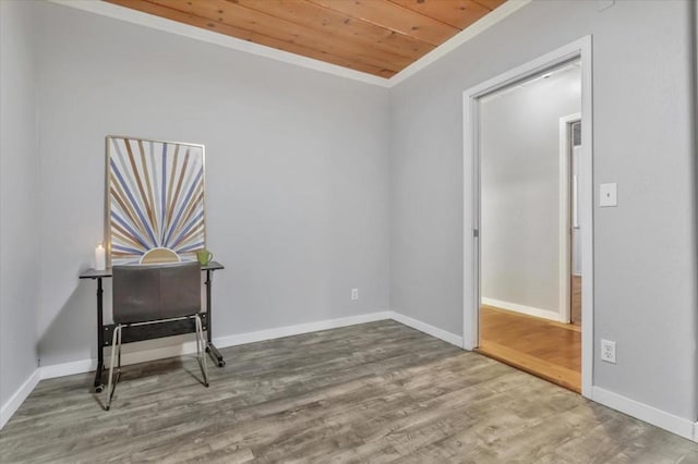 spare room featuring hardwood / wood-style floors, ornamental molding, and wood ceiling