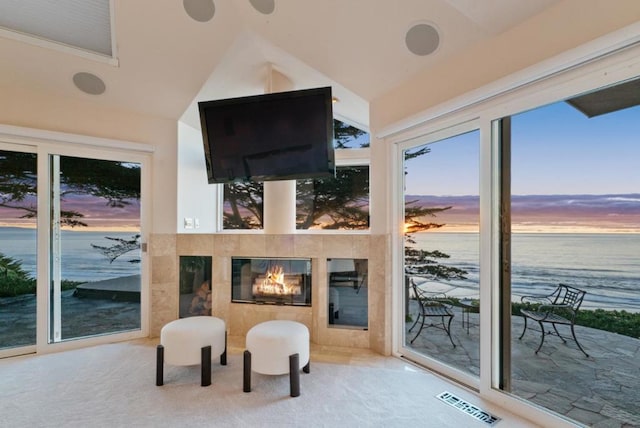 sunroom / solarium featuring lofted ceiling and a tiled fireplace