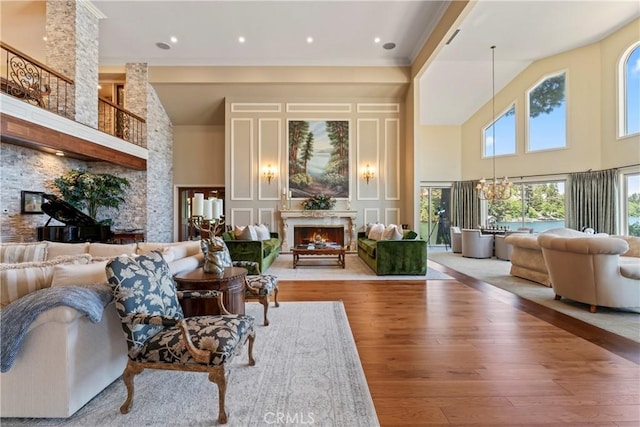 living room with a stone fireplace, light wood-type flooring, and high vaulted ceiling