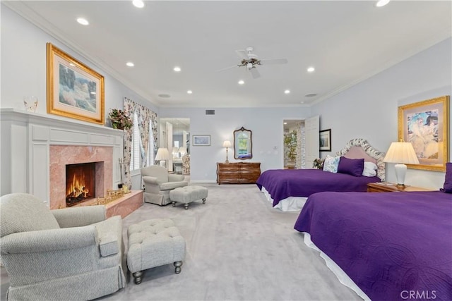 carpeted bedroom with ceiling fan, crown molding, and a high end fireplace