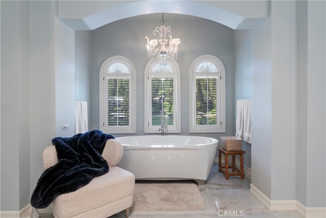 bathroom featuring a chandelier and a bath