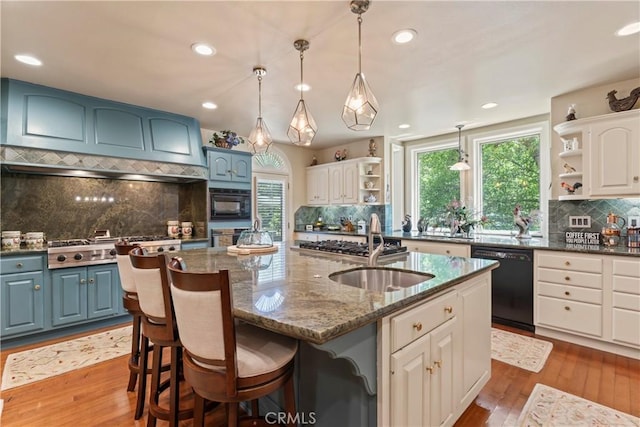 kitchen featuring blue cabinetry, a center island with sink, white cabinets, and black dishwasher