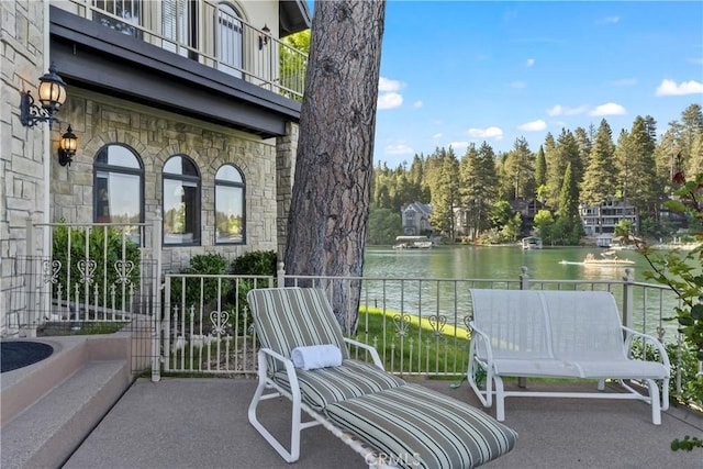 view of patio / terrace featuring a water view and a balcony