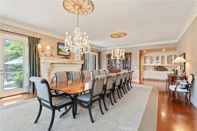 dining area with ornamental molding, light hardwood / wood-style floors, and an inviting chandelier