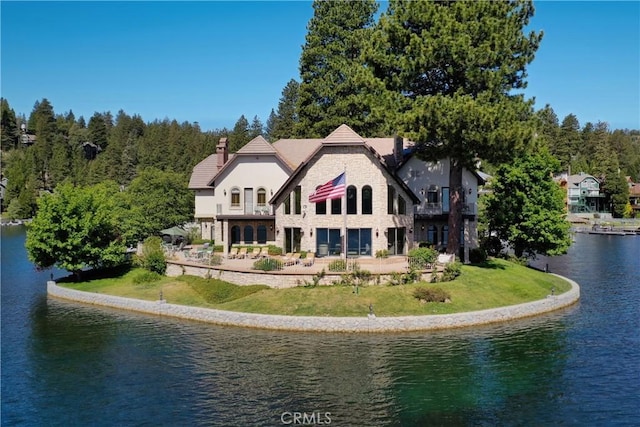 rear view of property with a yard and a water view