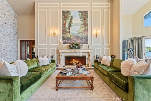 living room featuring a fireplace, french doors, and high vaulted ceiling