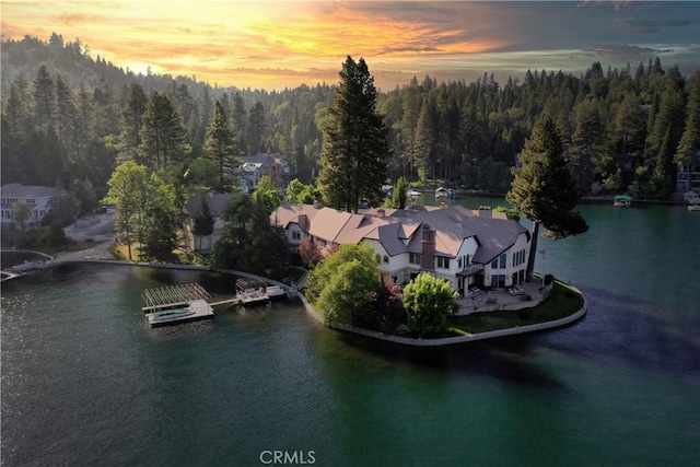 aerial view at dusk featuring a water view