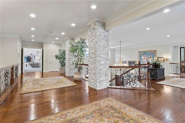 interior space with wood-type flooring, ornamental molding, and decorative columns