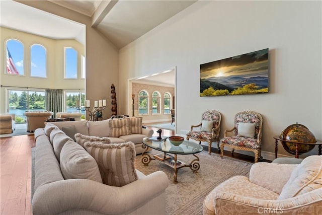 living room with a healthy amount of sunlight, wood-type flooring, and ornamental molding