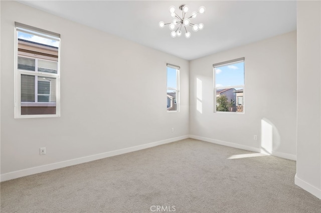 empty room with a notable chandelier, plenty of natural light, and light colored carpet