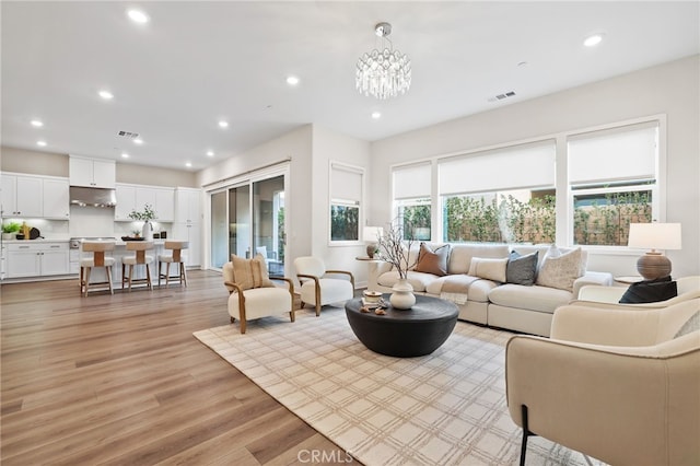 living room with a notable chandelier and light hardwood / wood-style flooring