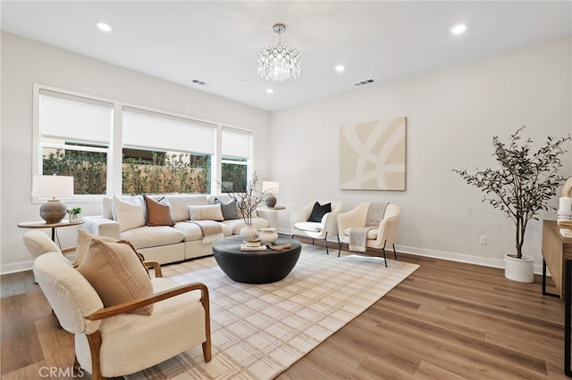 living room with hardwood / wood-style floors and an inviting chandelier