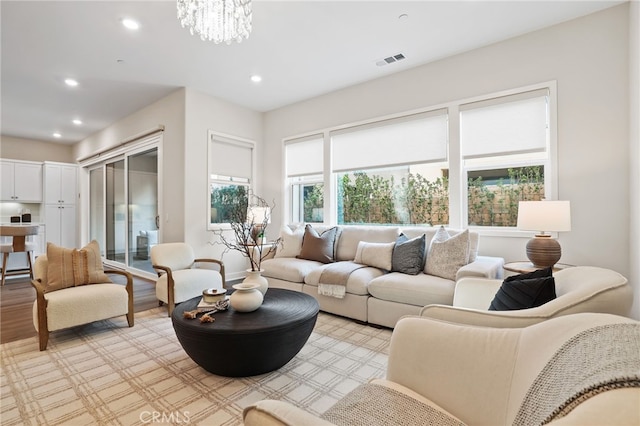 living room with an inviting chandelier and light hardwood / wood-style flooring