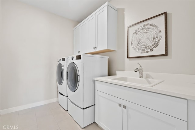 laundry room featuring washer and dryer, light tile patterned floors, cabinets, and sink