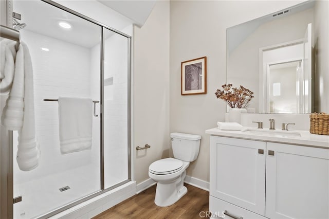 bathroom featuring toilet, a shower with door, vanity, and hardwood / wood-style flooring