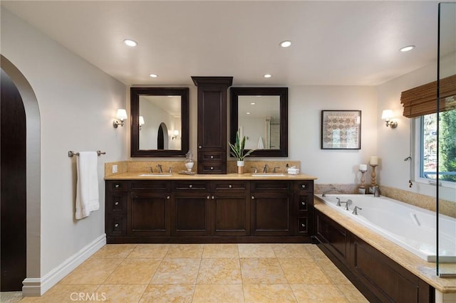 bathroom featuring a tub to relax in, tile patterned flooring, and vanity