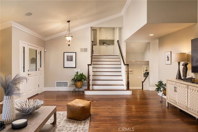 foyer entrance featuring ornamental molding and dark hardwood / wood-style flooring