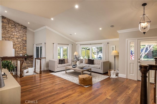 living room with wood-type flooring, an inviting chandelier, vaulted ceiling, and crown molding