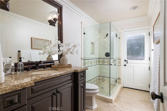 bathroom featuring vanity, toilet, ornamental molding, and a shower with shower door