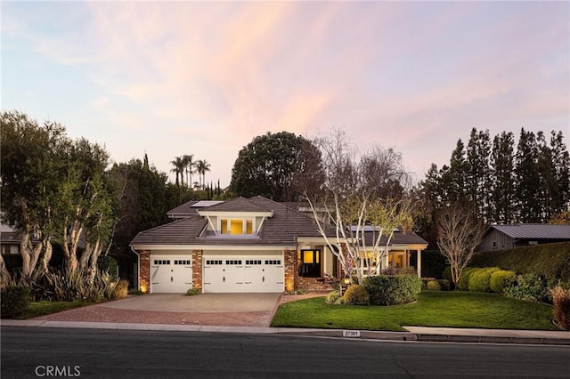 view of front of property with a garage and a lawn