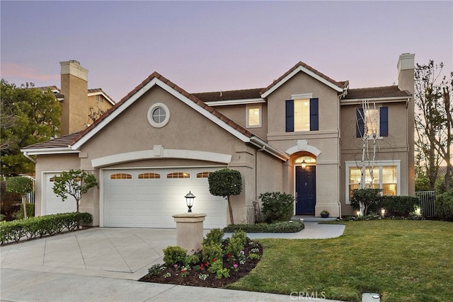 view of property featuring a lawn and a garage