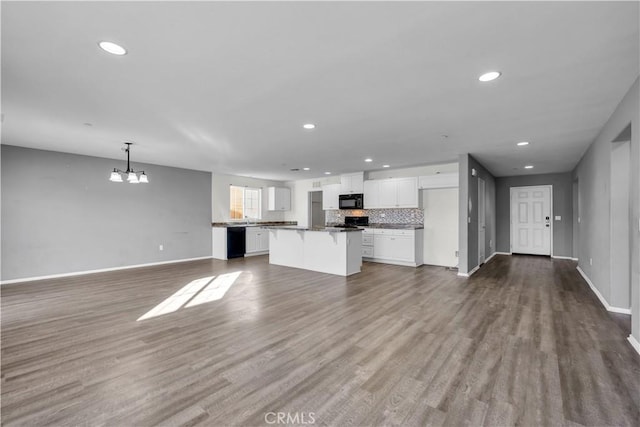 kitchen with decorative light fixtures, white cabinets, an inviting chandelier, a kitchen island, and black appliances