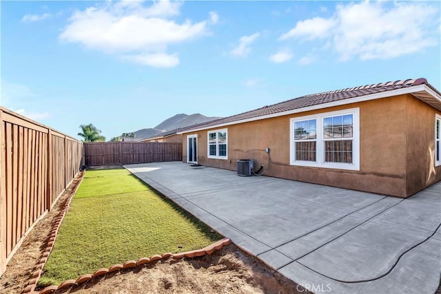 rear view of property with cooling unit and a patio