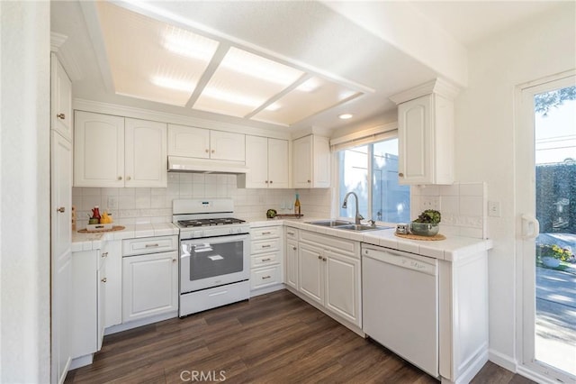 kitchen featuring white appliances, white cabinetry, dark hardwood / wood-style flooring, sink, and tile countertops