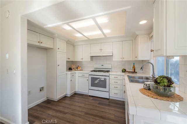 kitchen featuring tile countertops, white cabinetry, backsplash, white gas range oven, and sink