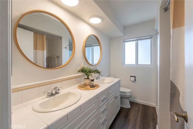 bathroom featuring hardwood / wood-style floors, toilet, vanity, and a shower with curtain