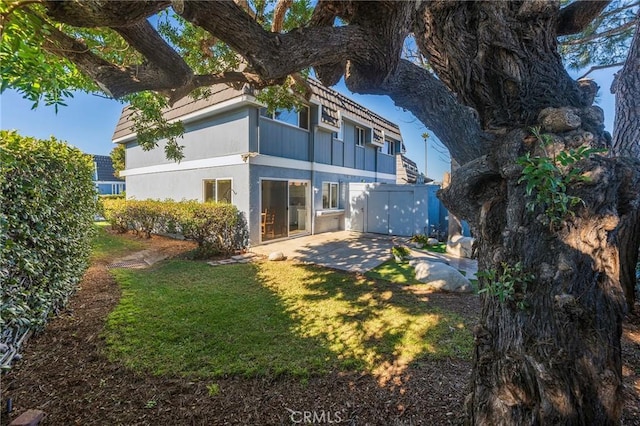 rear view of property featuring a patio area and a yard