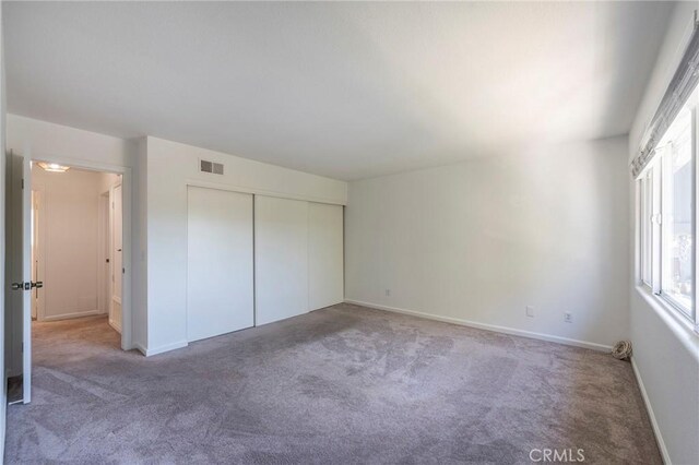 unfurnished bedroom with a closet and carpet flooring