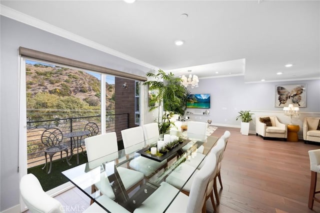 dining area featuring hardwood / wood-style floors, crown molding, and a notable chandelier