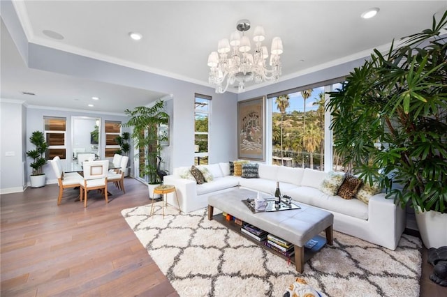 living room with hardwood / wood-style floors, ornamental molding, and a notable chandelier