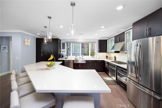 kitchen featuring a kitchen island, sink, a kitchen breakfast bar, and appliances with stainless steel finishes