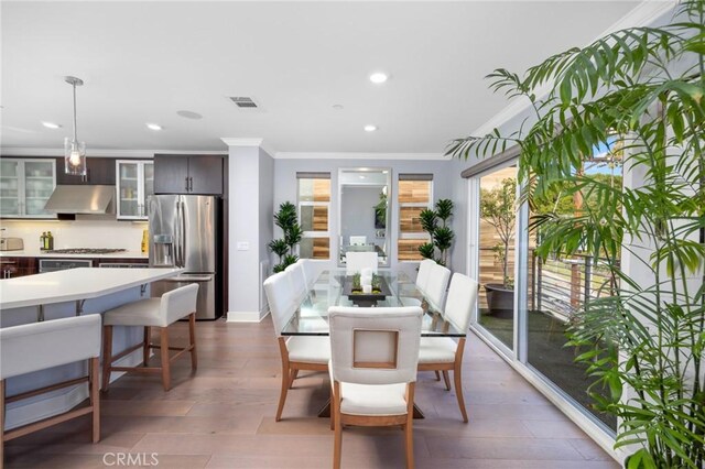 dining space featuring dark hardwood / wood-style floors and crown molding