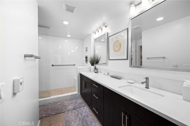 bathroom featuring vanity and tiled shower