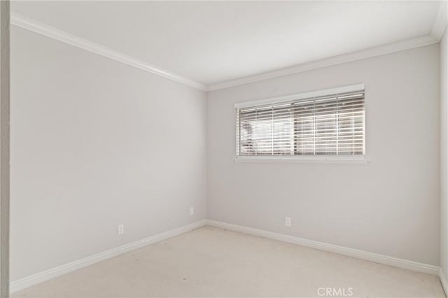 unfurnished room featuring light colored carpet and crown molding