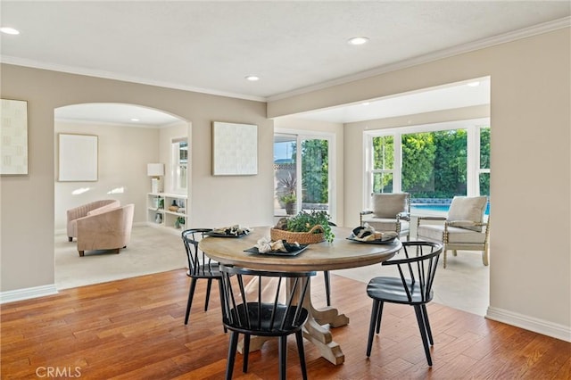 dining space with hardwood / wood-style flooring and ornamental molding