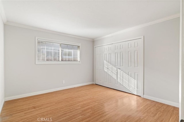 unfurnished bedroom with a closet, ornamental molding, and light hardwood / wood-style flooring