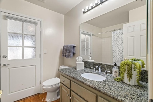 bathroom with a shower with curtain, hardwood / wood-style floors, toilet, and vanity