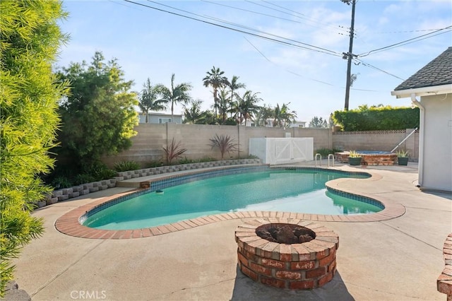 view of swimming pool featuring an outdoor fire pit and a patio