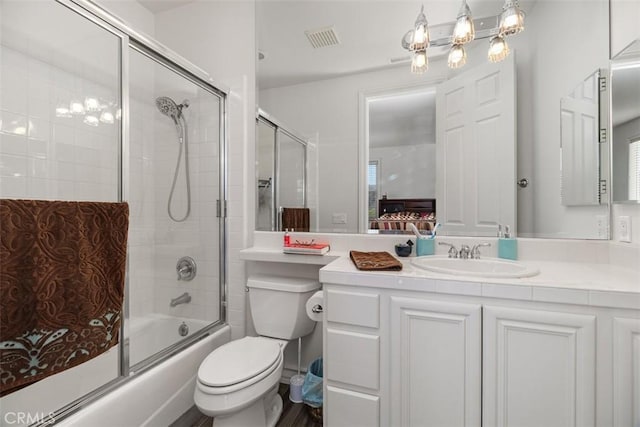 full bathroom with toilet, vanity, and bath / shower combo with glass door