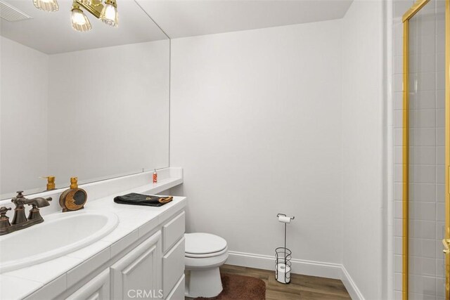 bathroom with hardwood / wood-style floors, vanity, and toilet