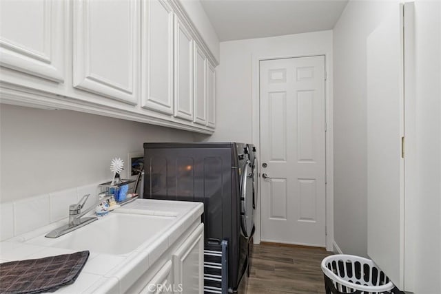 washroom featuring sink, washer and clothes dryer, cabinets, and dark wood-type flooring