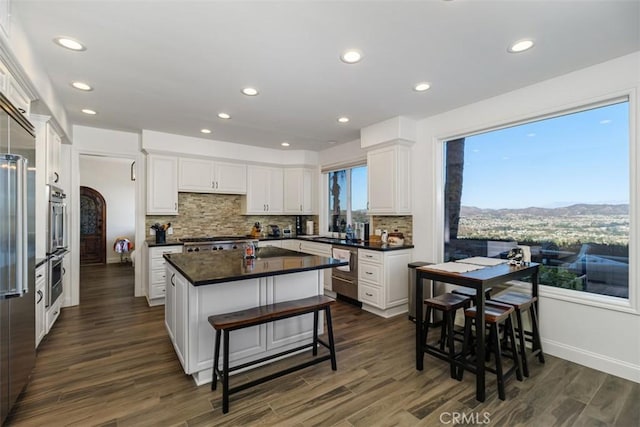 kitchen featuring a kitchen island, white cabinetry, and dark wood-type flooring