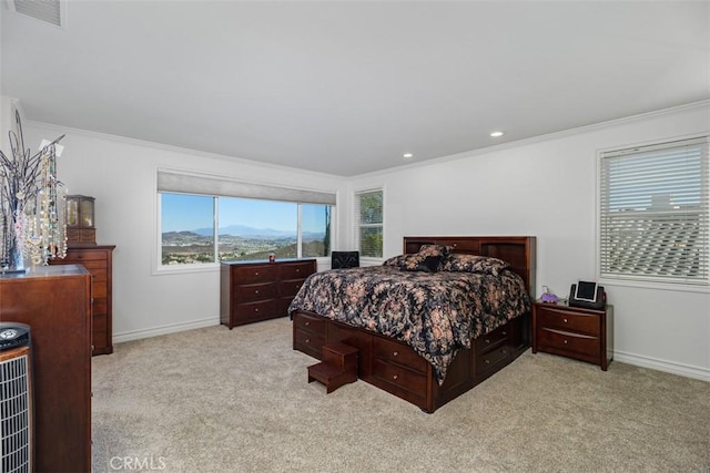 bedroom with ornamental molding and light colored carpet