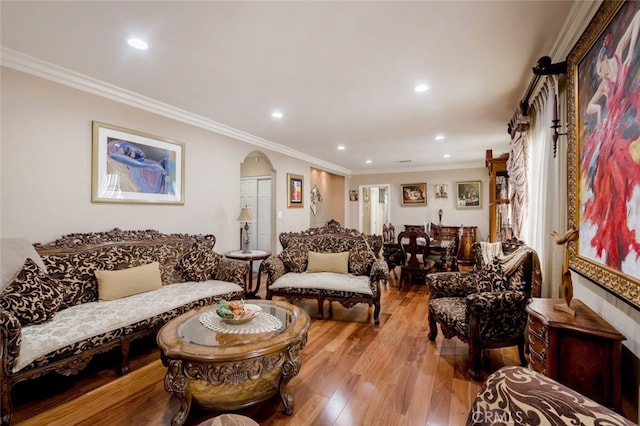 living room with light wood-type flooring and ornamental molding