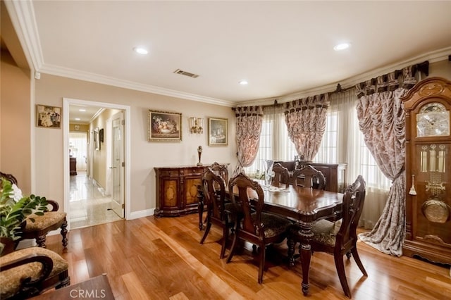 dining area featuring crown molding and hardwood / wood-style floors